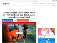 Bild zum Artikel: Zwei Polizisten retten einen Hund, der mit der Leine aus dem Fenster eines Fahrzeugs hängt