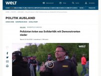 Bild zum Artikel: Polizisten knien aus Solidarität mit Demonstranten nieder