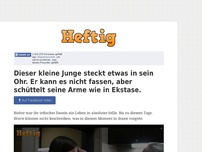 Bild zum Artikel: Dieser kleine Junge steckt etwas in sein Ohr. Er kann es nicht fassen, aber schüttelt seine Arme...