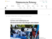 Bild zum Artikel: Gärtner setzt Schlafsäcke von demonstrierenden Flüchtlingen unter Wasser